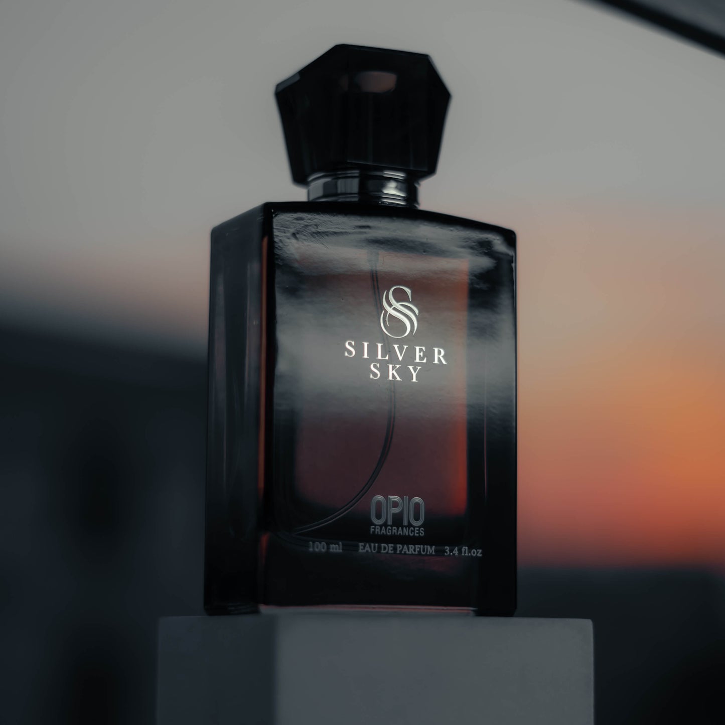 A black perfume bottle with a clear liquid, branded Silver Sky by Opio.
