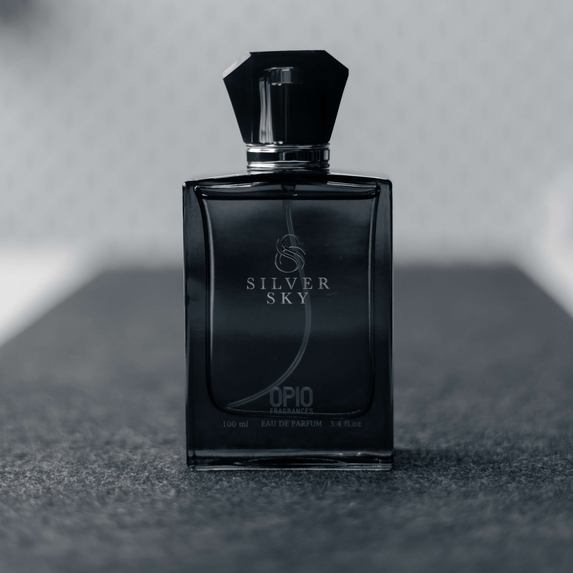 A black perfume bottle with a clear liquid, branded Silver Sky by Opio.