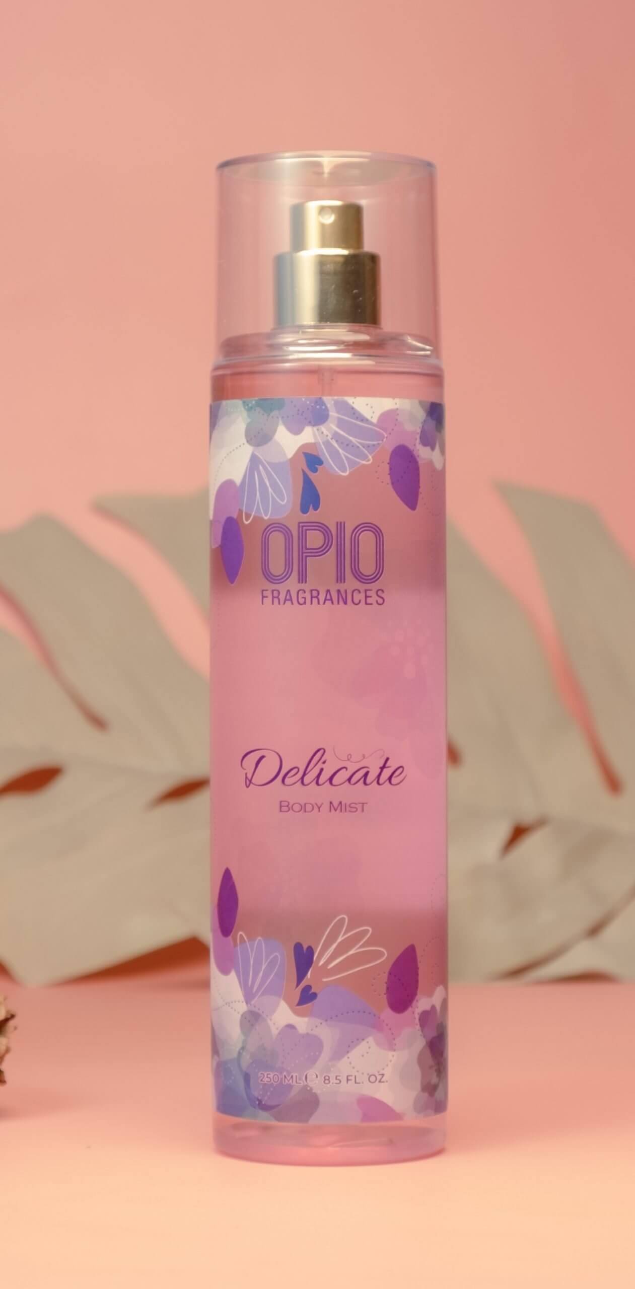 A bottle of DELICATE BODYMIST for women, with a pink label and floral design.