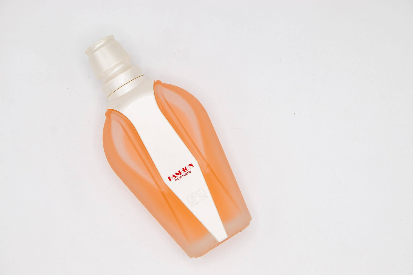 Peach-colored perfume bottle with a pearl strip in a light pink box decorated with musical notes.