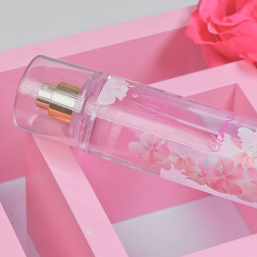 Close-up bottle of 'GLAMOUR' body mist for women with a floral design