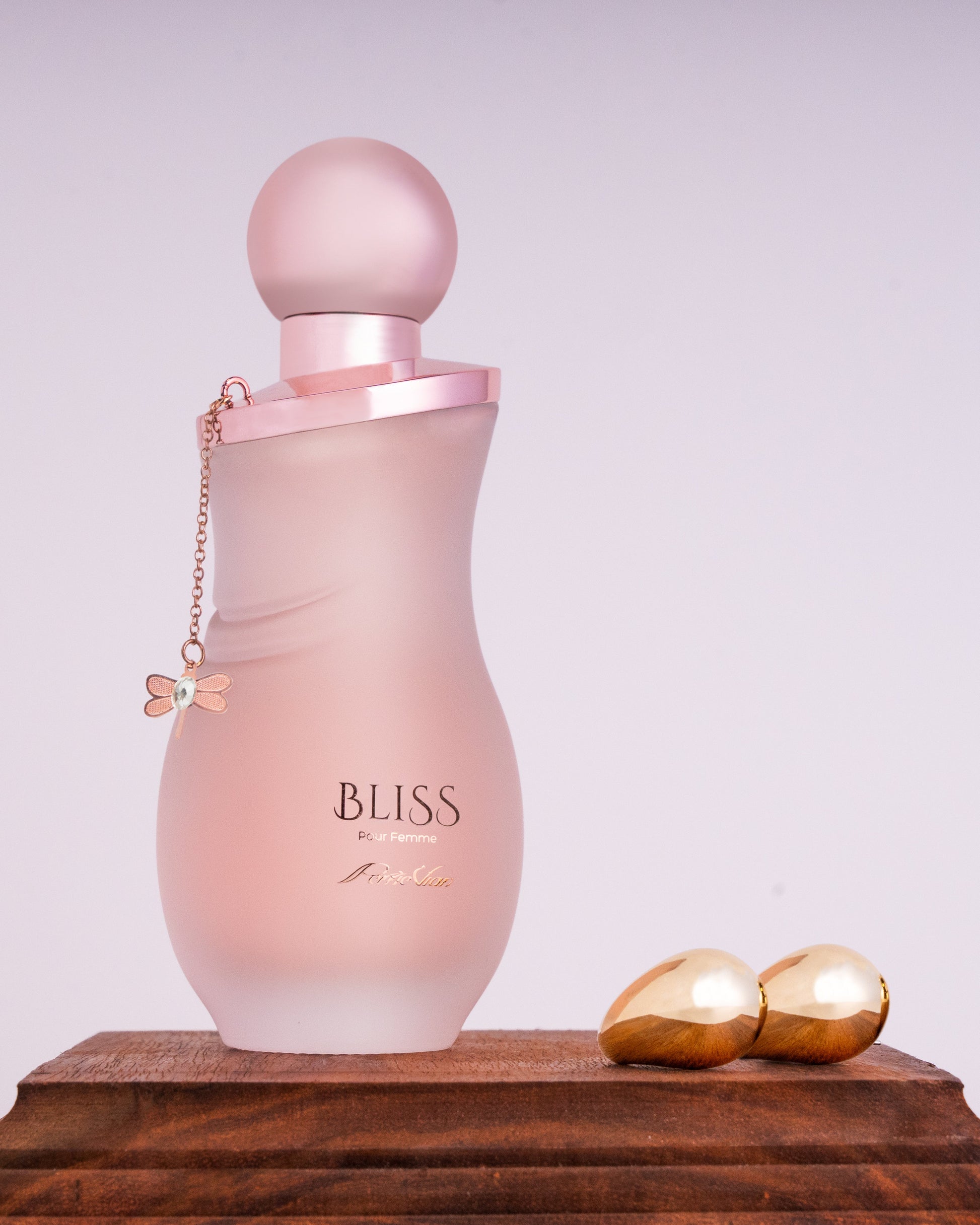 A bottle of 'Bliss' perfume for women, with a pink label and cap.