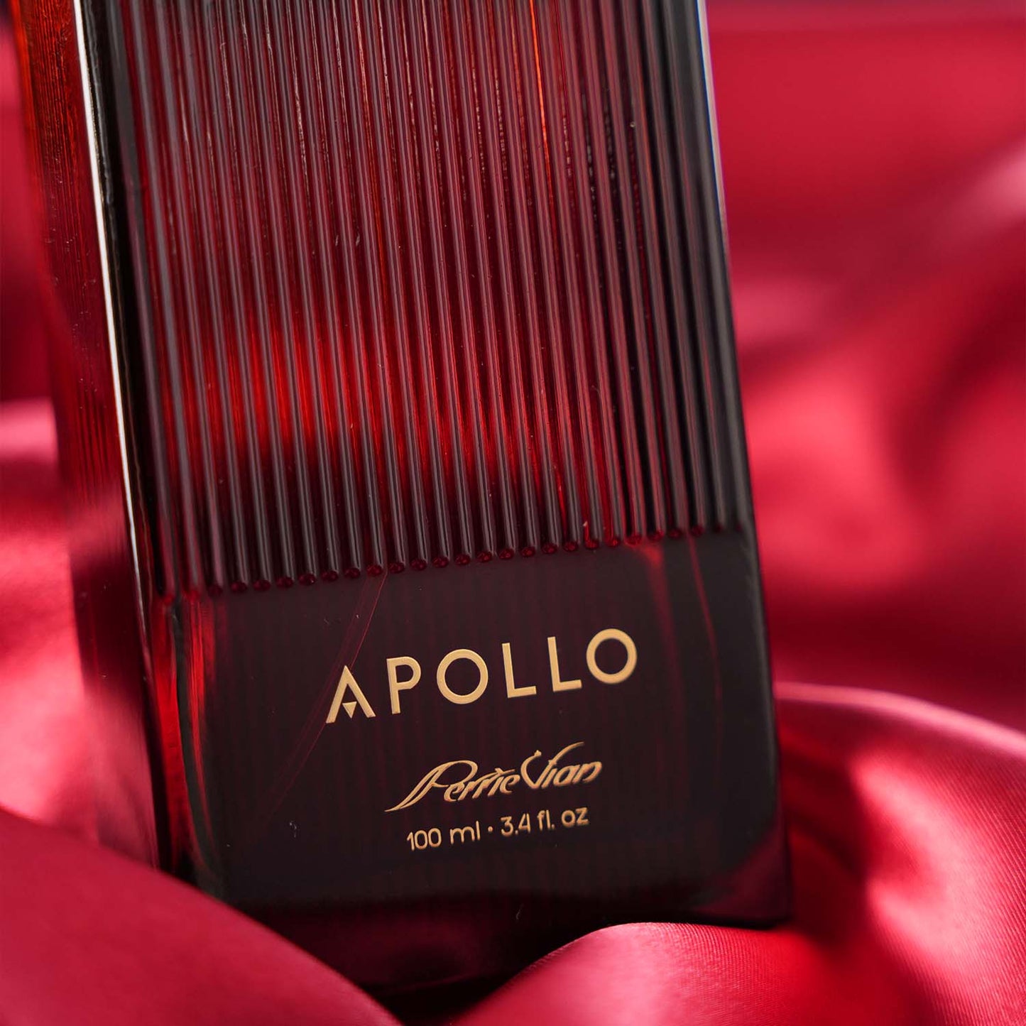 Perfume bottle labeled 'Apollo' on red satin background