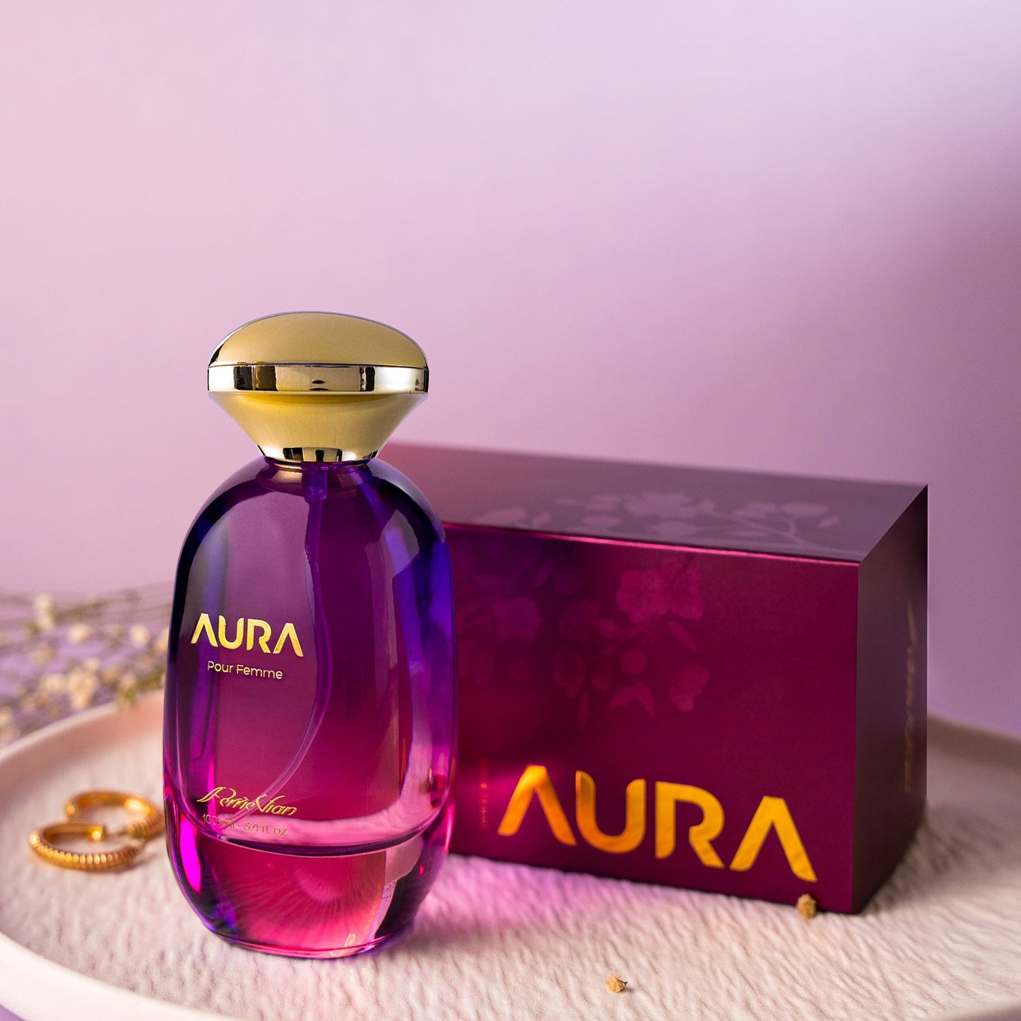 Aura Perfume bottle and packaging on a pink background