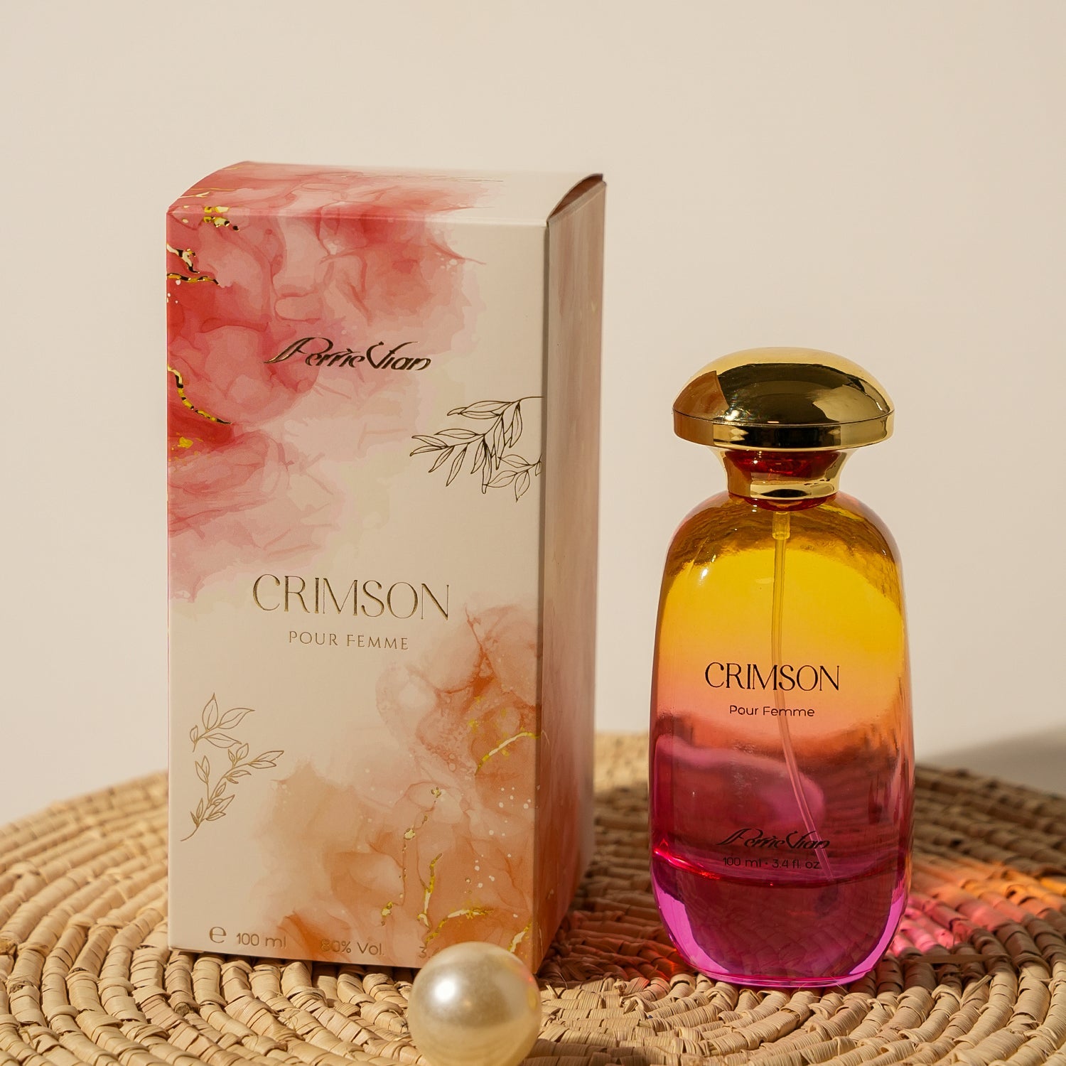 Perfume bottle and packaging on a woven mat with a pearl.