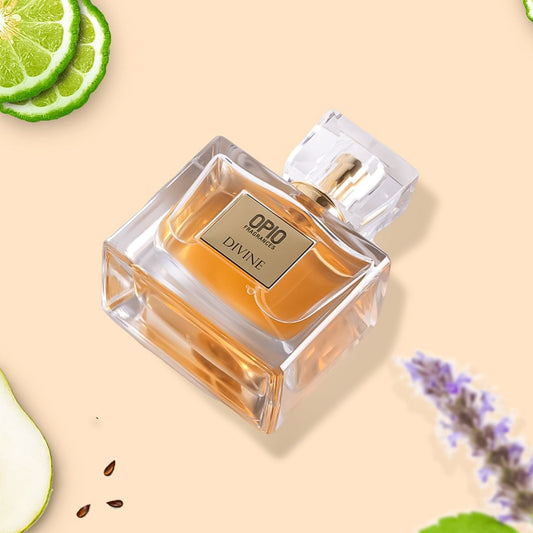 A clear bottle of perfume labeled 'DIVINE' with a transparent cap, surrounded by slices of lime and flowers, indicating the fragrance notes.