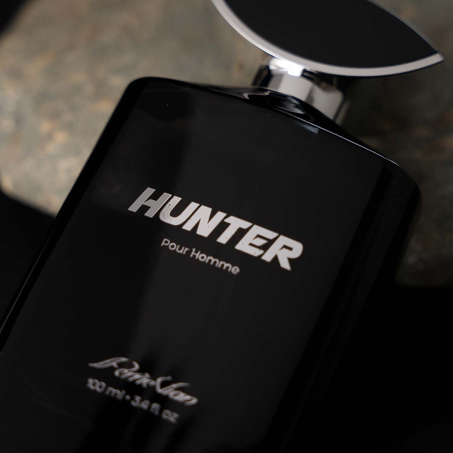 Black perfume bottle with 'Hunter pour Homme' text on a dark background.